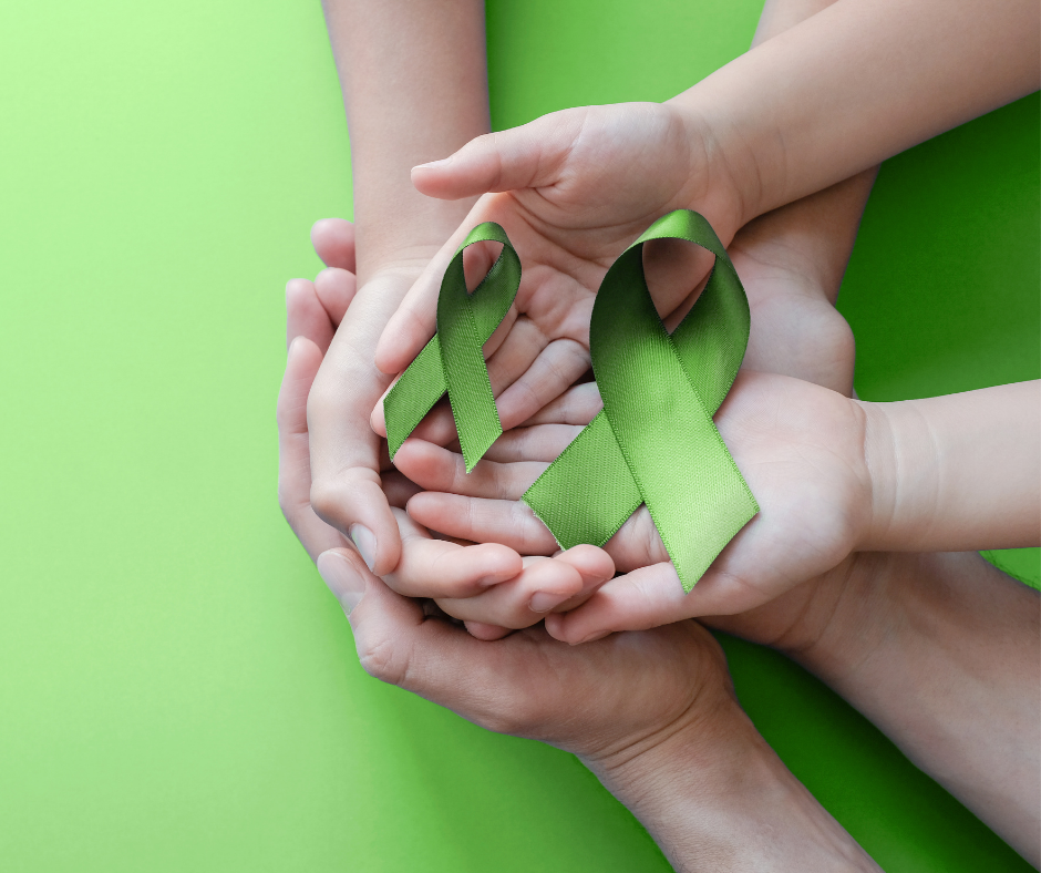 hands with green awareness ribbons hands with green awareness ribbons